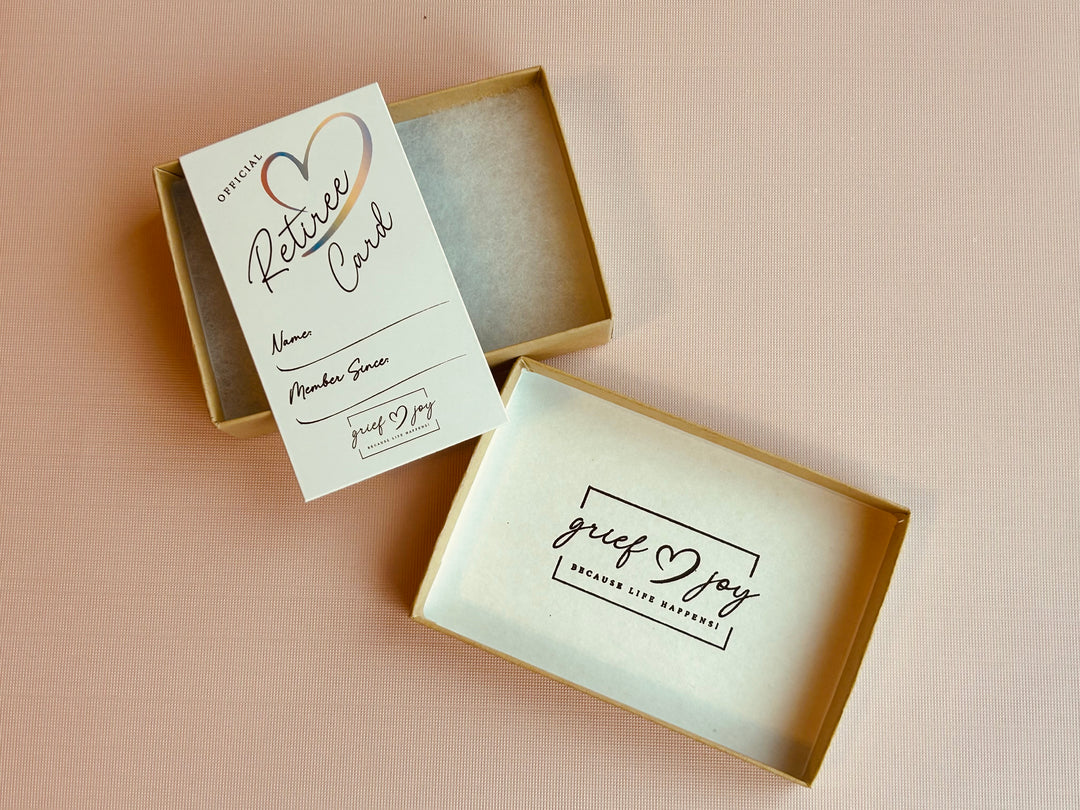 Grief & Joy Official Retiree Card laying on top of gift box